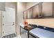 Convenient laundry room with front-load washer/dryer and ample overhead cabinet space at 3181 Firenze Pl, Highlands Ranch, CO 80126