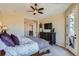 Well-lit main bedroom featuring a dark dresser, ceiling fan, and access to balcony at 3181 Firenze Pl, Highlands Ranch, CO 80126