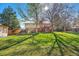 Large green backyard with a wooden deck and wood fence, providing ample privacy at 7065 S Willow St, Centennial, CO 80112