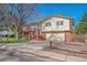 Traditional exterior featuring a two-car garage and a charming brick facade at 7065 S Willow St, Centennial, CO 80112