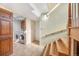 Hallway with laundry room entrance, wooden stairs, and tiled flooring at 7065 S Willow St, Centennial, CO 80112