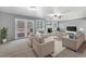 Bright living room boasts ample seating, brick fireplace, and access to an outdoor deck at 7065 S Willow St, Centennial, CO 80112