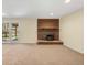 Cozy living room features a brick fireplace, neutral carpet, and access to the outdoors at 7065 S Willow St, Centennial, CO 80112