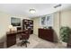 Home office with a wooden desk, bookcase, and natural light from the window at 7065 S Willow St, Centennial, CO 80112