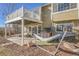 Inviting backyard featuring a hammock, playhouse, string lights, and patio beneath a spacious second-story deck at 314 Woodstock Ln, Castle Pines, CO 80108