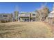 Spacious backyard featuring a deck with a white railing, a lush green lawn, and mature trees at 314 Woodstock Ln, Castle Pines, CO 80108