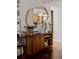 Close up shot of the credenza in the living room; shows a gold mirror and hardwood floors at 6530 W 26Th Ave, Edgewater, CO 80214