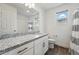 Well-lit bathroom with granite countertops, sleek fixtures, and a shower featuring stylish tile accents at 10123 Zeno St, Commerce City, CO 80022