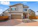 Inviting two-story home showcasing a brick driveway, gray siding and a two-car garage at 10123 Zeno St, Commerce City, CO 80022