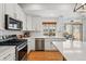 Bright kitchen featuring stainless appliances, white cabinets and herringbone backsplash at 10123 Zeno St, Commerce City, CO 80022