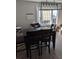 Dining room with wooden table, chairs, and modern chandelier with ample sunlight streaming in at 305 Strong St, Brighton, CO 80601