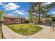 Brick home featuring a lush green lawn, beautiful backyard with patio furniture, and manicured landscaping at 882 E Briarwood Cir, Centennial, CO 80122