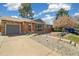Inviting brick home with a covered front porch, well-manicured lawn, and blooming tree at 882 E Briarwood Cir, Centennial, CO 80122