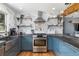 Modern kitchen with stainless steel oven, range hood, marble backsplash, and open shelving at 882 E Briarwood Cir, Centennial, CO 80122