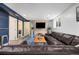 Finished basement living room with a comfortable leather sectional sofa, wood feature wall, and large window at 882 E Briarwood Cir, Centennial, CO 80122