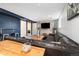 Cozy basement living room featuring a large leather sectional and stylish wood accent wall with a mounted TV at 882 E Briarwood Cir, Centennial, CO 80122