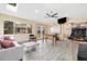 Sun room with laminate floors, bright windows, ceiling fan, foosball table, and access to outdoor living at 882 E Briarwood Cir, Centennial, CO 80122
