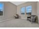 Cozy bedroom featuring two accent chairs, neutral walls, and natural light from several windows at 14667 Crouch Pl, Parker, CO 80134