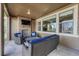 A covered patio offering outdoor furniture, stone fireplace with mounted television, and neighborhood views at 14667 Crouch Pl, Parker, CO 80134