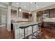 Bright kitchen boasts a large island with barstool seating, stainless appliances, and pendant lighting at 14667 Crouch Pl, Parker, CO 80134