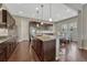 Open kitchen featuring dark wood cabinets, granite countertops, stainless steel appliances, and a dining area at 14667 Crouch Pl, Parker, CO 80134