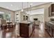 Open-concept kitchen with dark wood cabinetry, stainless steel appliances and a view to the dining and living areas at 14667 Crouch Pl, Parker, CO 80134