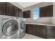 Laundry room with a modern washer and dryer, ample cabinets, and a sink for added convenience at 14667 Crouch Pl, Parker, CO 80134