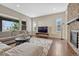 Bright living room features modern furnishings, a cozy fireplace, and large windows for ample natural light at 14667 Crouch Pl, Parker, CO 80134