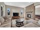 Spacious living room featuring a stone fireplace, comfortable seating, and ample natural light at 14667 Crouch Pl, Parker, CO 80134