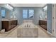 A main bathroom with large soaking tub surrounded with decorative tile, double sinks and tile flooring at 14667 Crouch Pl, Parker, CO 80134