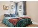 Inviting bedroom with a colorful bedspread, large windows, and neutral-toned walls at 1734 Kingston St, Aurora, CO 80010