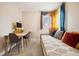 Bright bedroom features a daybed, desk, and colorful curtains near a well-lit window at 1734 Kingston St, Aurora, CO 80010