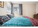 Comfortable bedroom showcasing a bright window, stylish bedding, and carpeted floors at 1734 Kingston St, Aurora, CO 80010