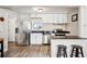 The kitchen has stainless steel appliances, white cabinets, black counters and a breakfast bar at 1734 Kingston St, Aurora, CO 80010