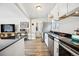 Open concept kitchen with stainless appliances, black countertops, and modern decor at 1734 Kingston St, Aurora, CO 80010