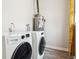 Laundry room with a Samsung washer and dryer, water heater, and wood look floors at 1734 Kingston St, Aurora, CO 80010