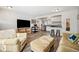 Open living room featuring wood floors, a television, and a stainless steel refrigerator in an adjacent kitchen at 1734 Kingston St, Aurora, CO 80010