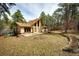 Backyard featuring a large lawn area, patio, and mature trees providing privacy at 530 Windmill Rd, Castle Rock, CO 80108