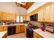 Modern kitchen with wood cabinets, countertops, tile backsplash, and black appliances at 530 Windmill Rd, Castle Rock, CO 80108