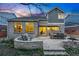 Stone patio with dining and seating areas, a fire pit, and exterior view of the two-story home at 7430 E Bayaud Ave, Denver, CO 80230