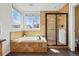 Bright bathroom featuring a soaking tub with tile surround and a glass enclosed shower at 7430 E Bayaud Ave, Denver, CO 80230