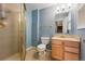 Bathroom with walk-in shower, blue walls, and natural wood vanity at 7430 E Bayaud Ave, Denver, CO 80230