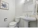 Cozy powder room with pedestal sink, white fixtures, and framed floral wall art at 7430 E Bayaud Ave, Denver, CO 80230