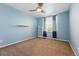 Bedroom with blue walls, carpet, window, and ceiling fan at 7430 E Bayaud Ave, Denver, CO 80230