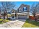 Charming two-story home featuring a welcoming front porch and a two-car garage with beautiful lawn at 7430 E Bayaud Ave, Denver, CO 80230
