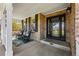 Inviting front porch with rocking chairs, brick wall, and black framed windows at 7430 E Bayaud Ave, Denver, CO 80230