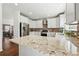 Bright kitchen with white cabinets, stainless steel appliances, tile backsplash, and granite countertops at 7430 E Bayaud Ave, Denver, CO 80230