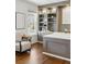 Well-lit office featuring hardwood floors, custom built-in shelving, desk, and neutral decor at 7430 E Bayaud Ave, Denver, CO 80230
