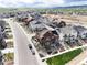 An aerial view highlights a vibrant community with modern homes, landscaping, and open spaces against a mountain backdrop at 9804 Rosalee Peak St, Littleton, CO 80125