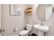 Chic powder room with pedestal sink, round mirror and elegant artwork at 9804 Rosalee Peak St, Littleton, CO 80125